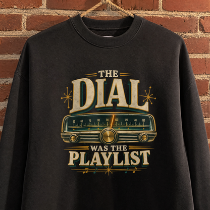 Black vintage sweatshirt hanging with printed “The Dial Was The Playlist” radio design.