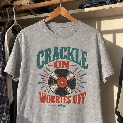 Gray vintage t-shirt hanging on wooden hanger, printed Crackle On Worries Off vinyl record design.