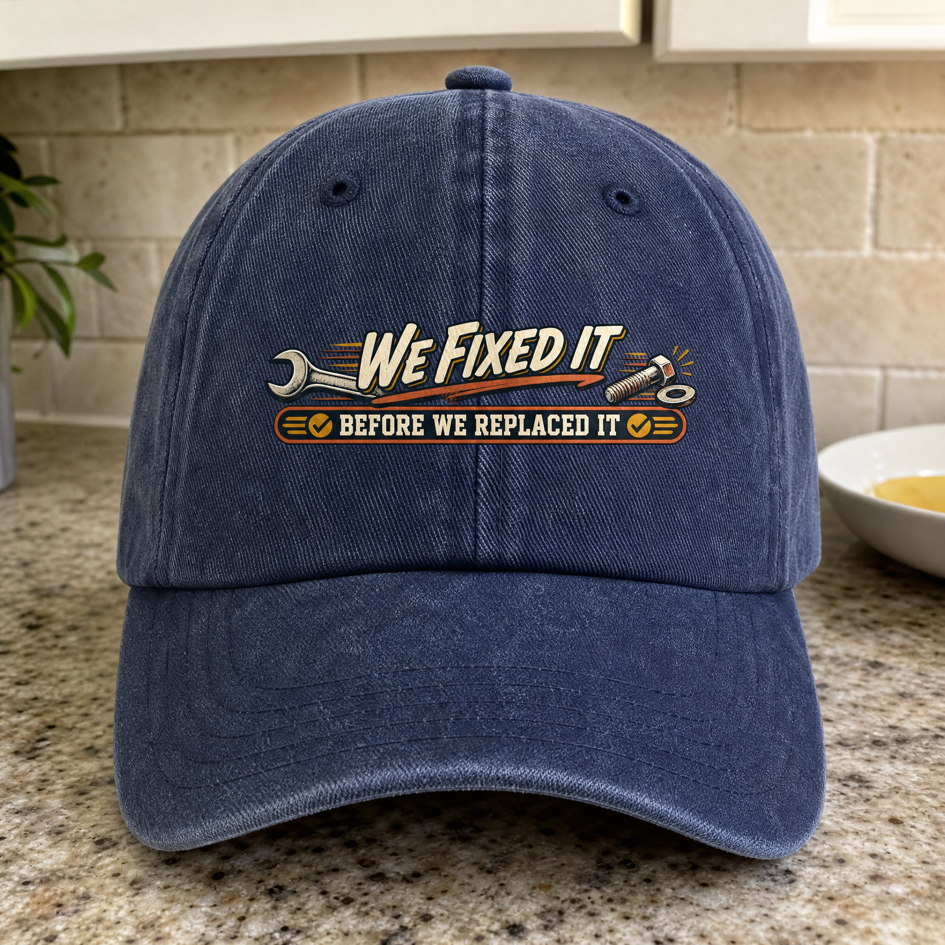 Navy vintage washed cap with printed “We Fixed It Before We Replaced It” slogan, front-facing.