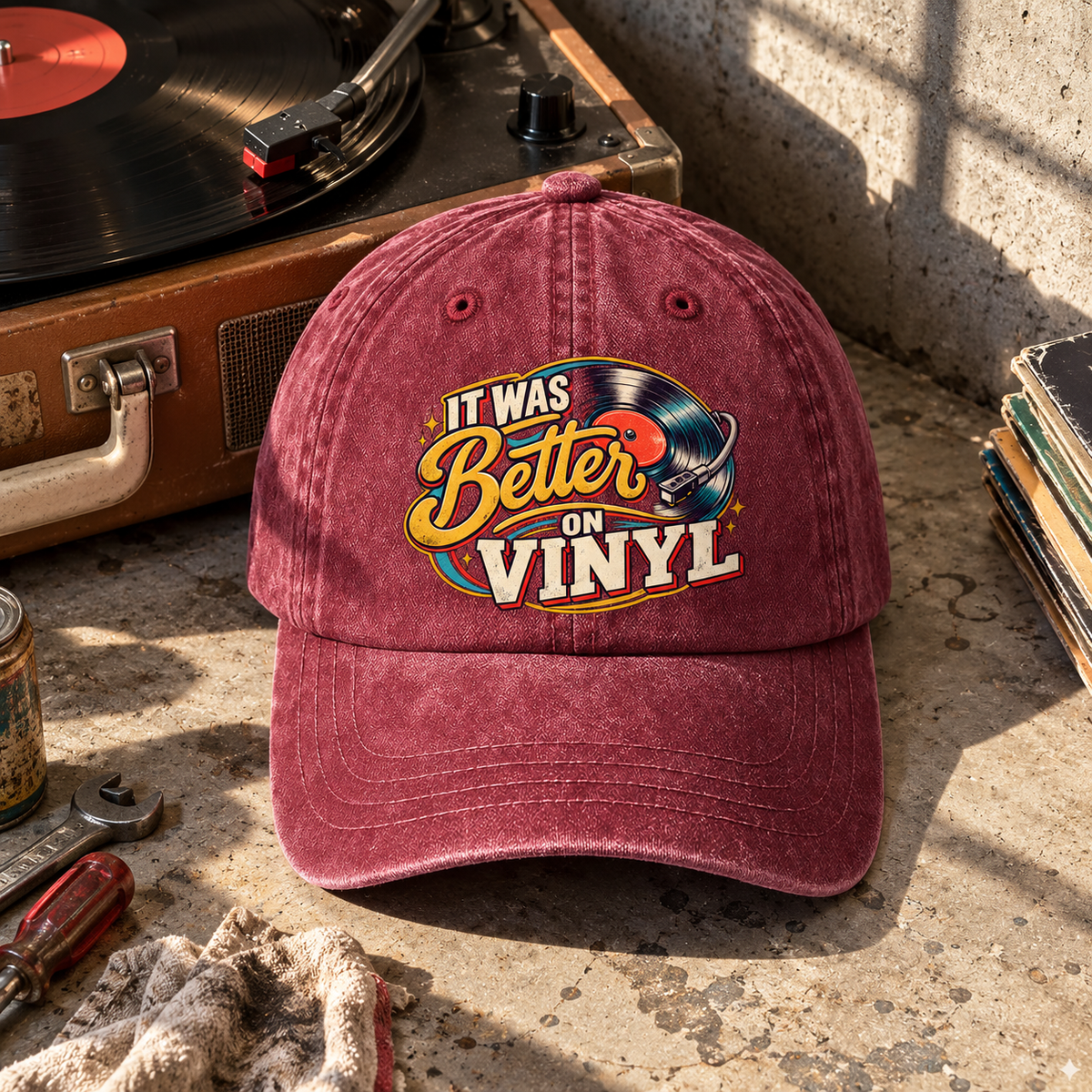 Burgundy vintage washed cap with printed It Was Better On Vinyl design beside turntable