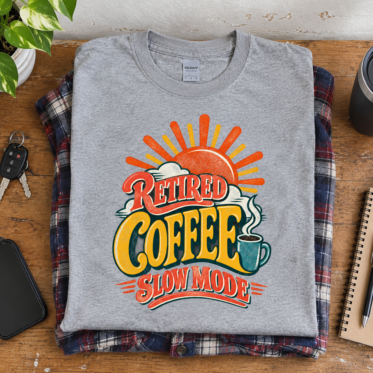 Gray vintage t-shirt featuring colorful printed “Retired Coffee Slow Mode” design, overhead view.