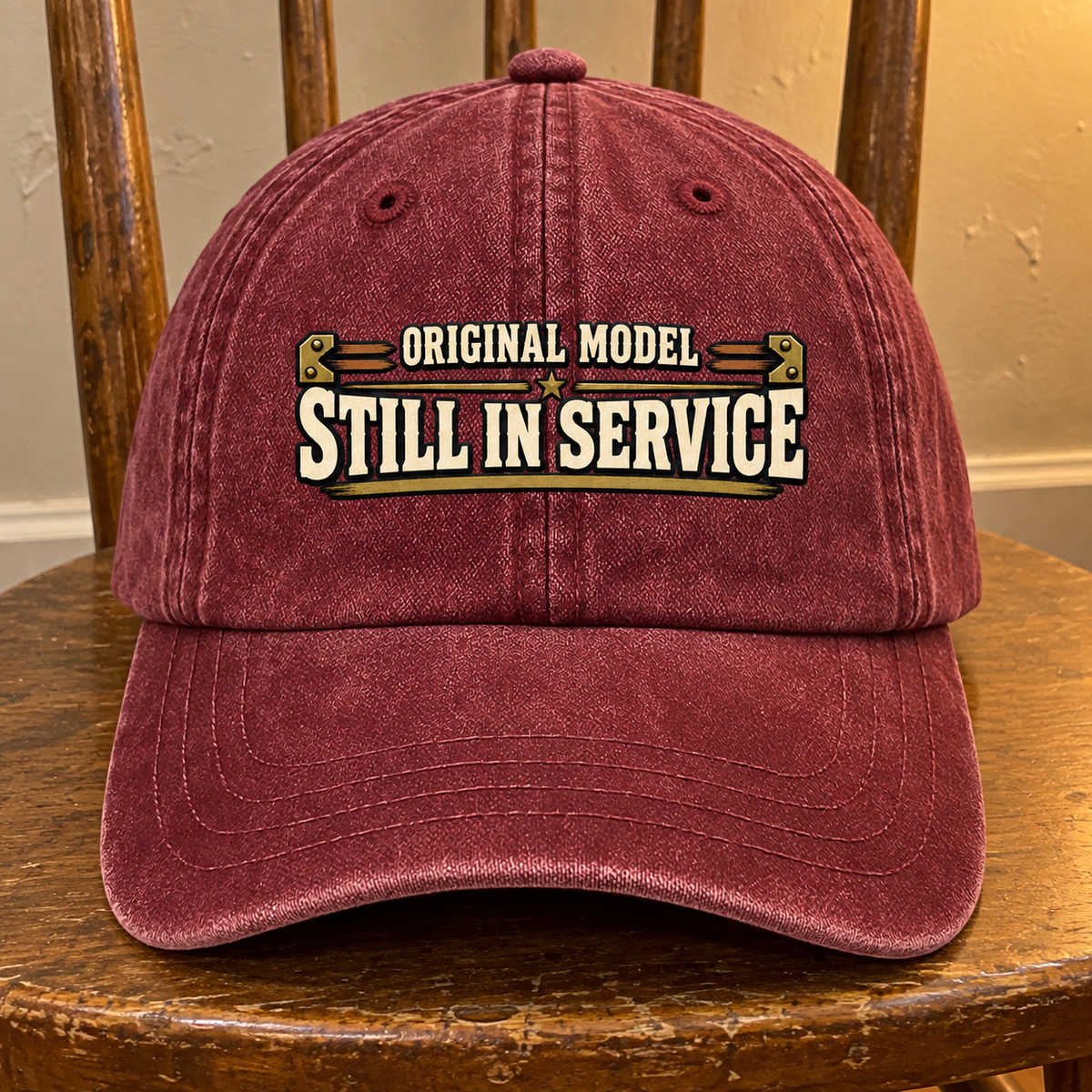 Front view of burgundy vintage washed cap with printed Original Model Still In Service slogan