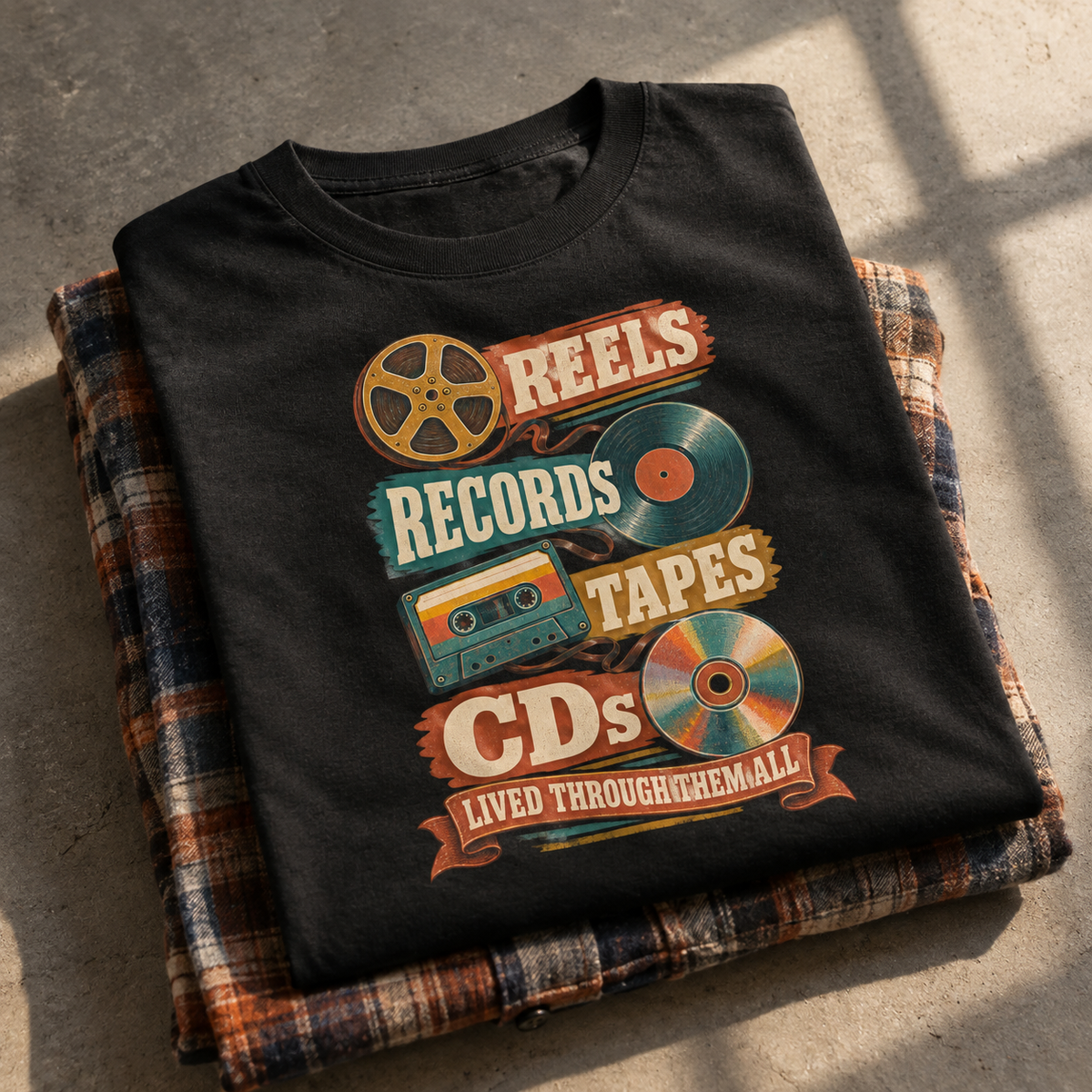 Black vintage t-shirt with printed reels, records, tapes, CDs, and retro slogan design