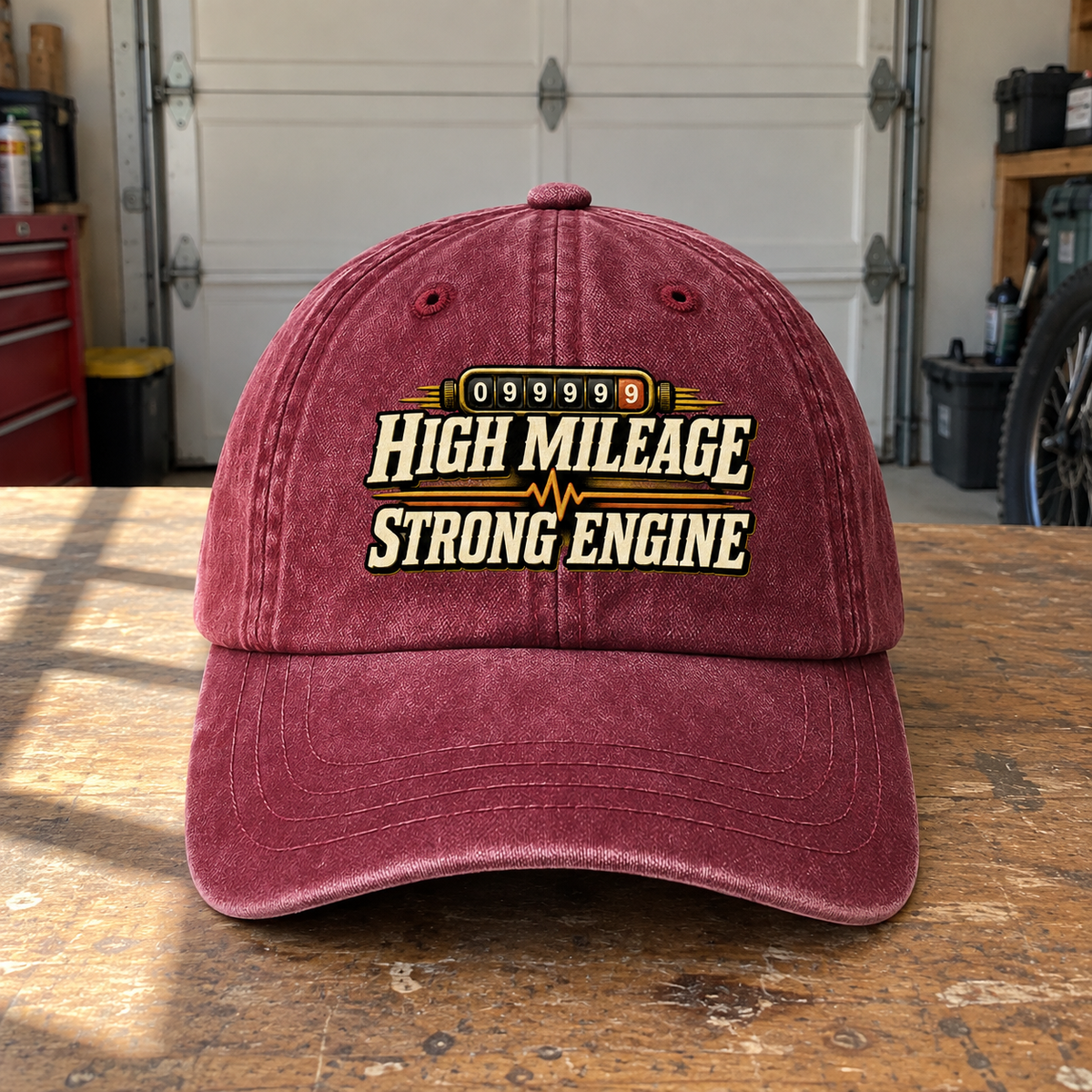 Front view of burgundy vintage washed cap with printed High Mileage Strong Engine design