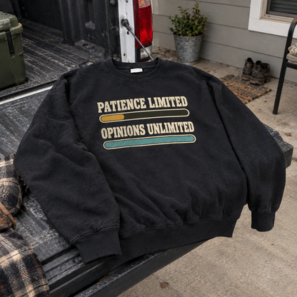 Black vintage sweatshirt with printed Patience Limited Opinions Unlimited slogan, displayed at an angle outdoors