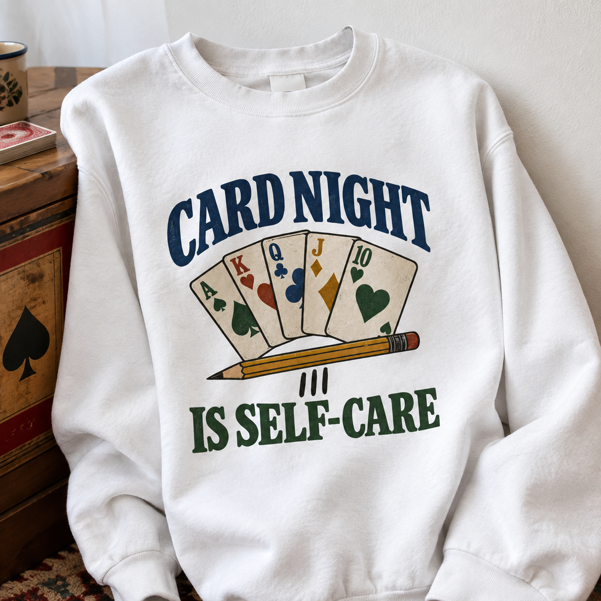 White vintage sweatshirt with printed Card Night Is Self-Care slogan and playing cards, front view