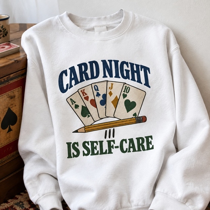 White vintage sweatshirt with printed Card Night Is Self-Care slogan and playing cards, front view