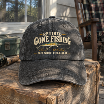 Black vintage washed cap with printed fishing slogan, front hero view on rustic wood.
