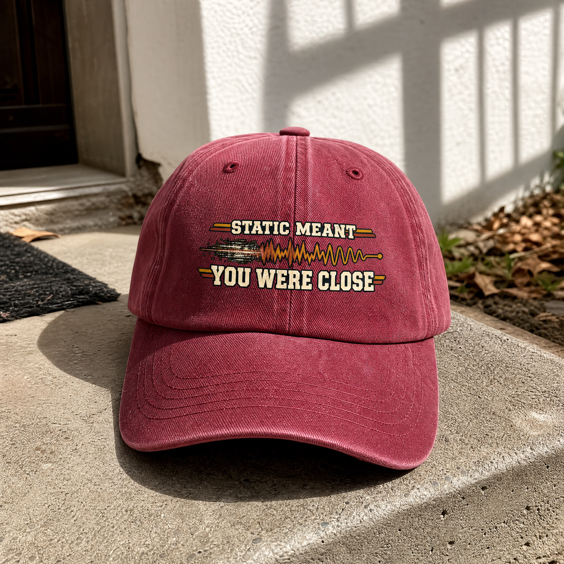 Pink vintage washed cap with printed “Static Meant You Were Close” slogan, front view.