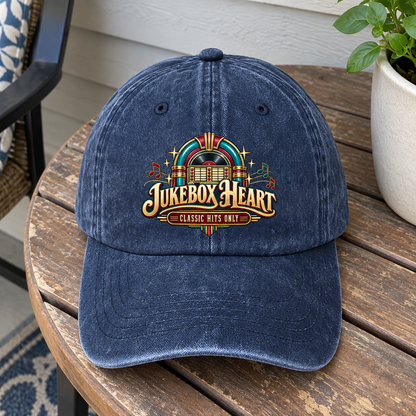 Navy vintage washed cap with printed Jukebox Heart Classic Hits Only design on wooden table
