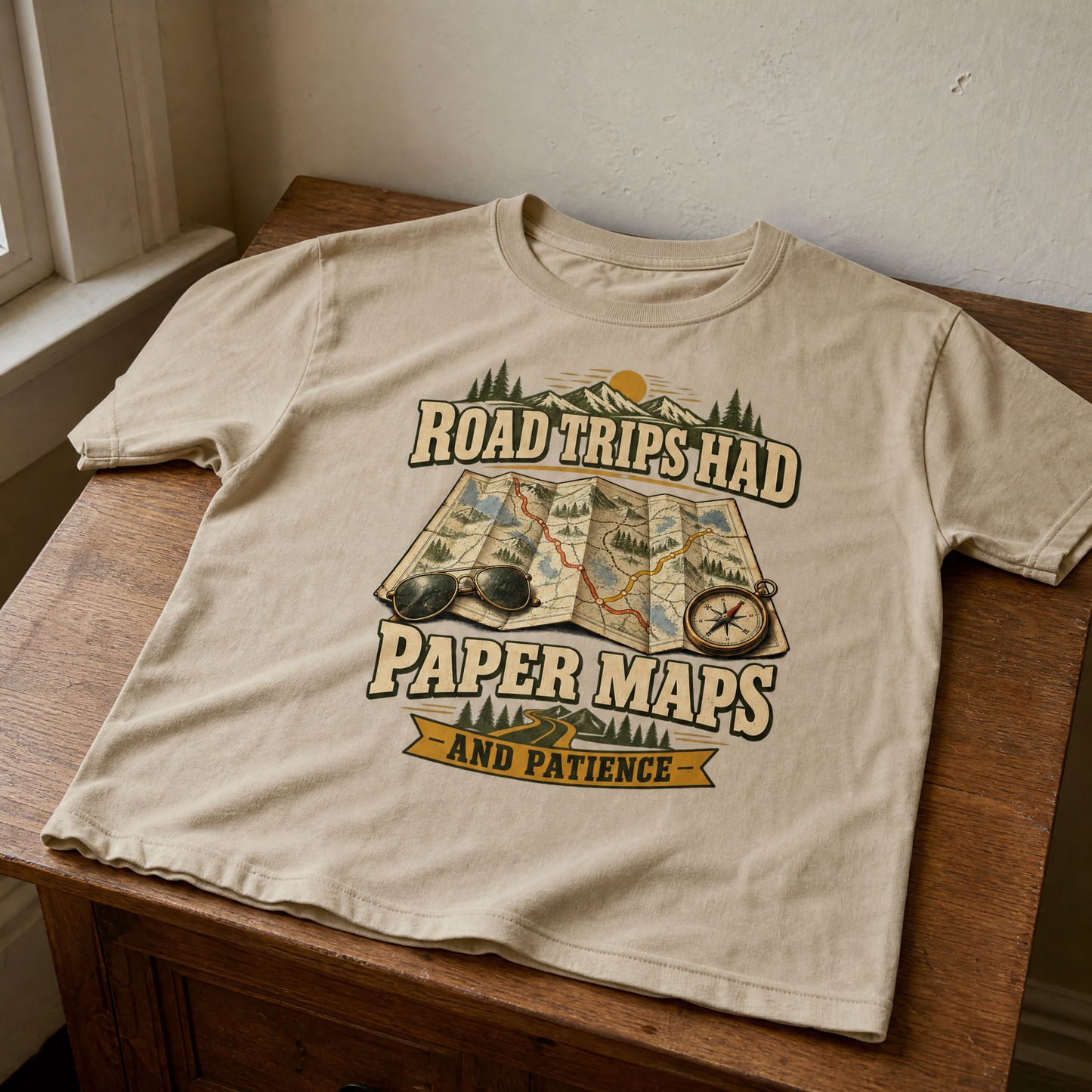 Cream vintage t-shirt with printed Road Trips Had Paper Maps And Patience design on table