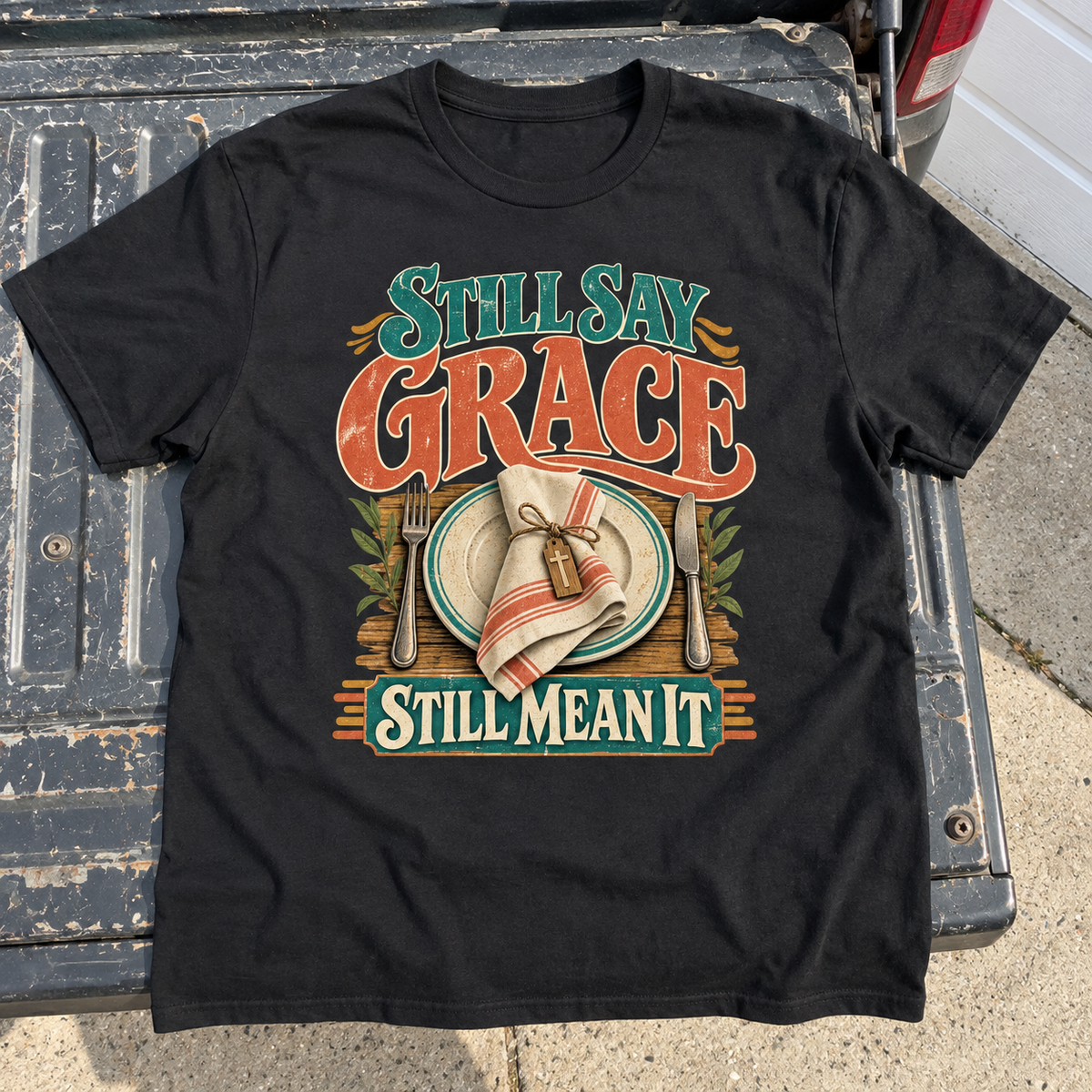 Black vintage t-shirt with printed Still Say Grace Still Mean It and table setting