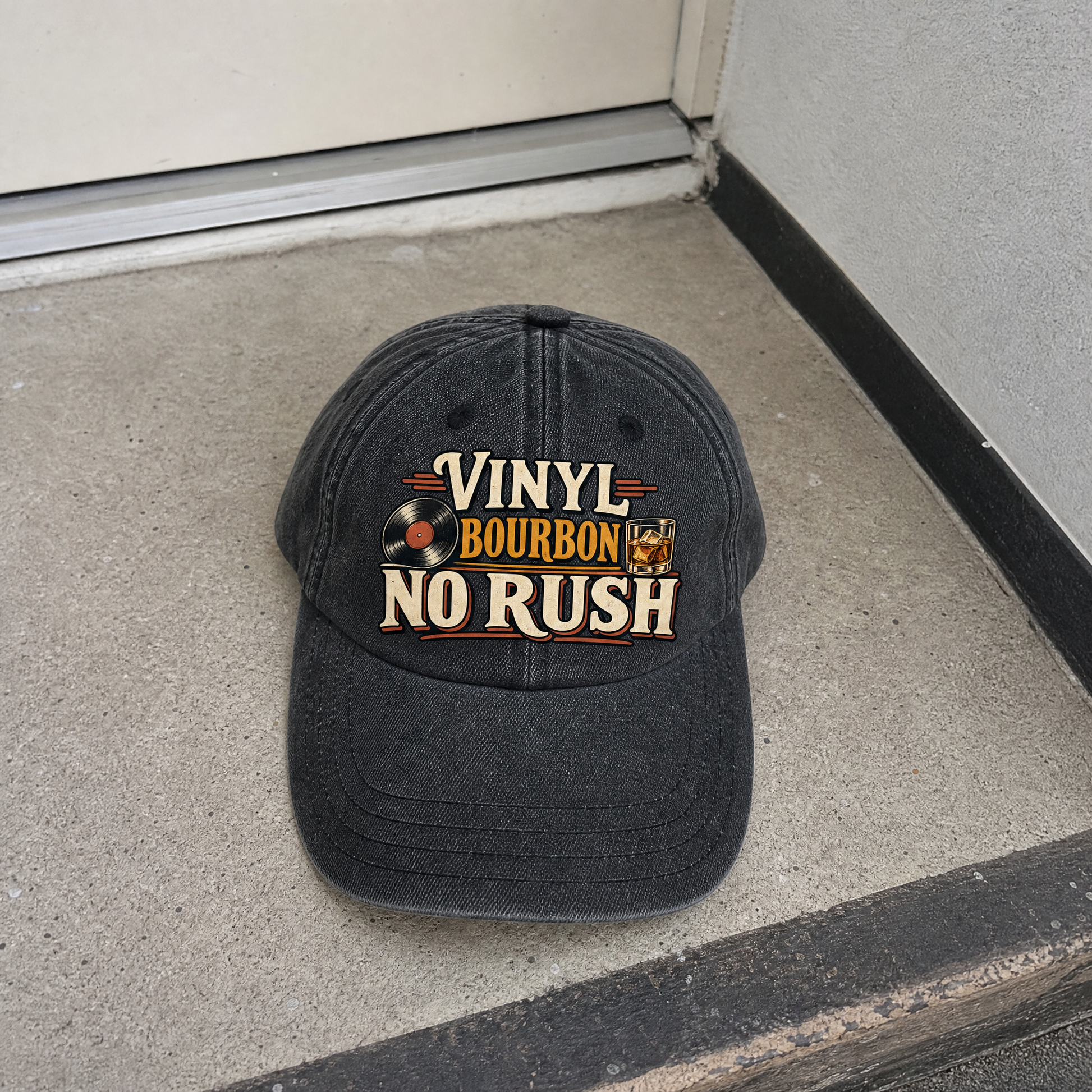 Black vintage washed cap featuring printed “Vinyl Bourbon. No Rush” slogan, hero view.
