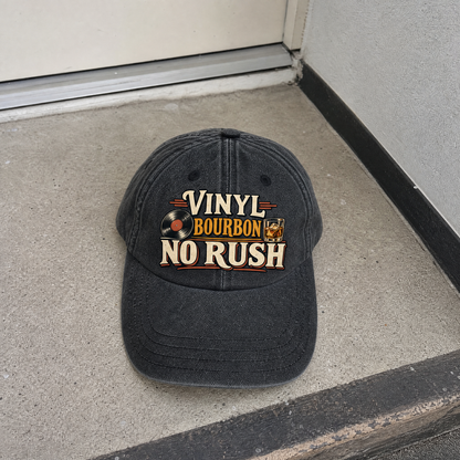 Black vintage washed cap featuring printed “Vinyl Bourbon. No Rush” slogan, hero view.