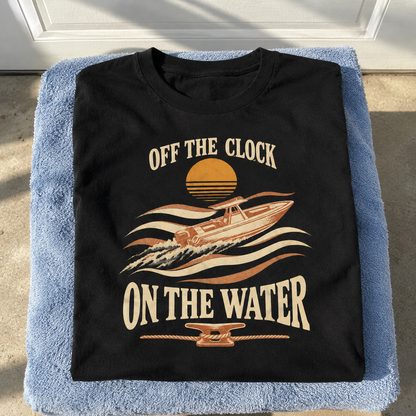 Black vintage t-shirt with printed boat, waves, sunset, and Off The Clock On The Water