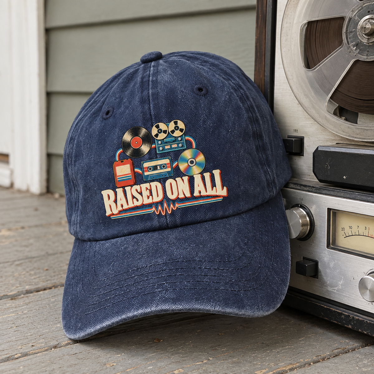 Navy vintage washed cap with printed Raised On All design beside reel-to-reel recorder