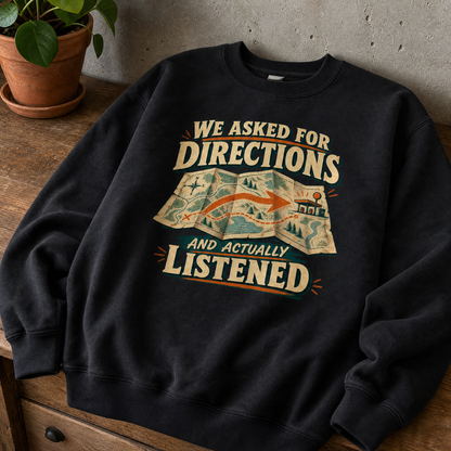 Black vintage sweatshirt with printed “We Asked For Directions And Actually Listened” slogan, overhead view.