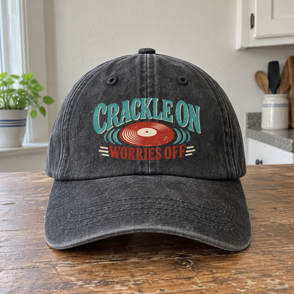 Front view of charcoal vintage washed cap with printed Crackle On Worries Off record design.