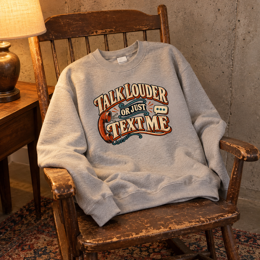 Gray vintage sweatshirt with printed Talk Louder Or Just Text Me design on wooden chair