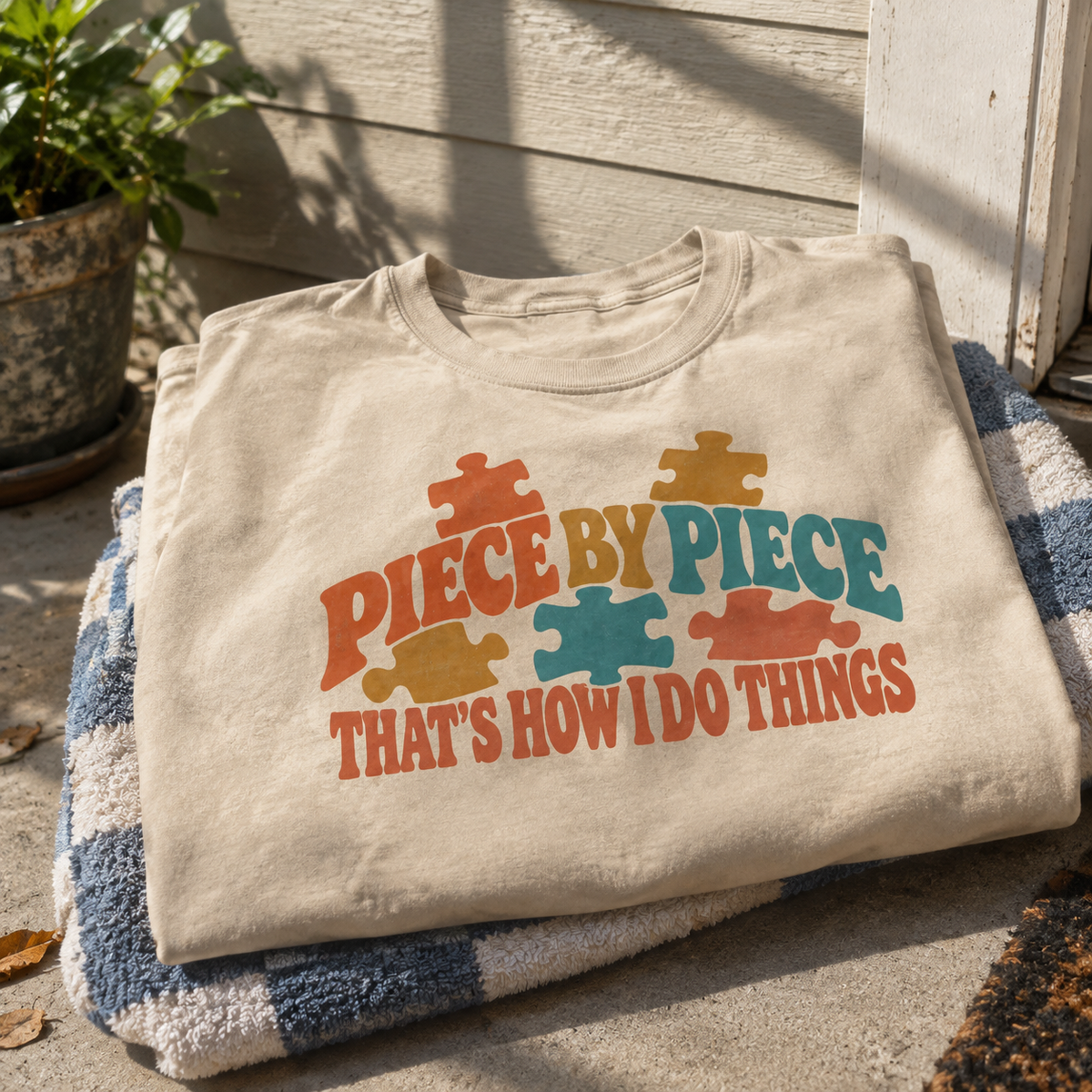 Vintage t-shirt with colorful printed puzzle pieces and Piece By Piece slogan, hero view