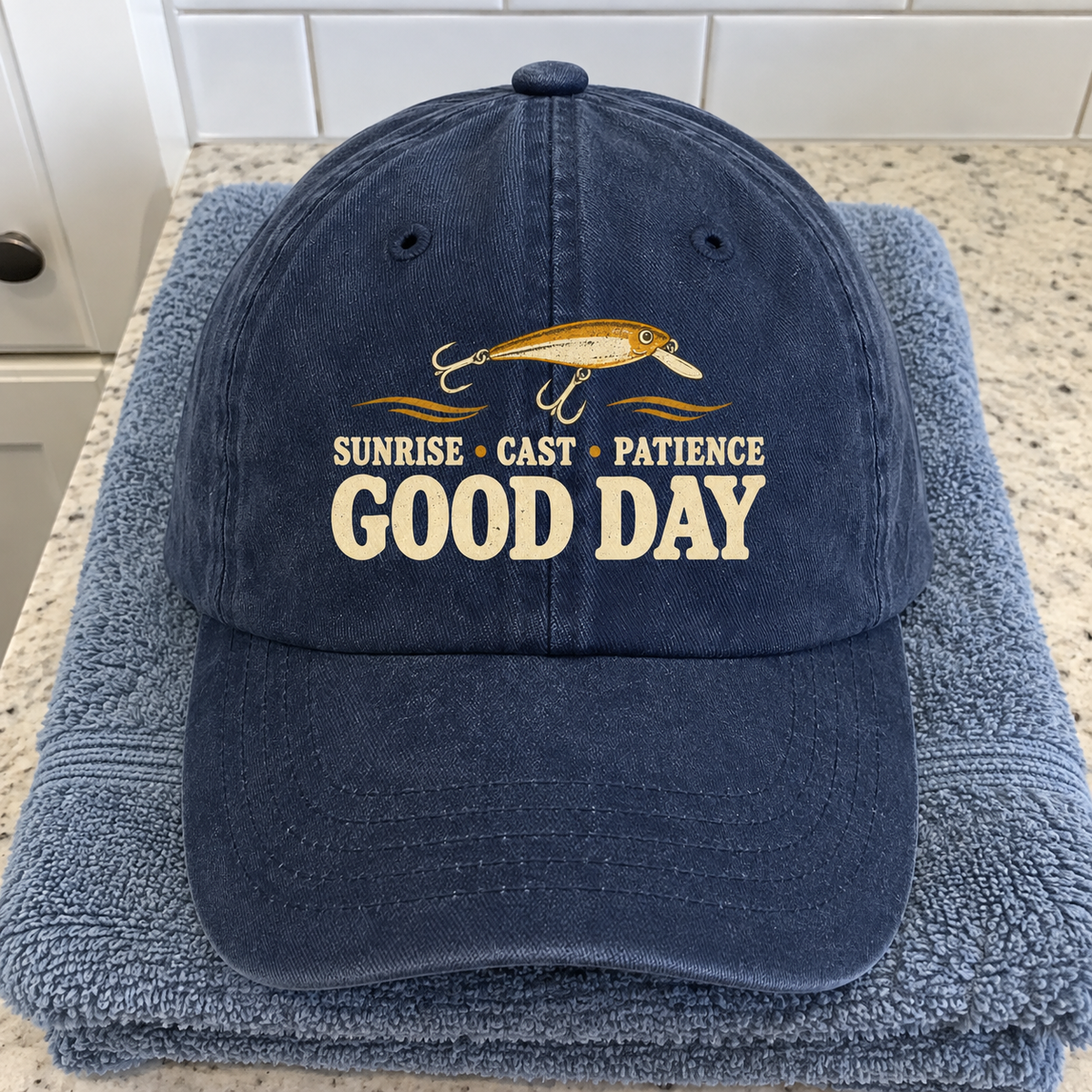 Navy vintage washed cap with printed “Sunrise • Cast • Patience. Good Day” fishing design