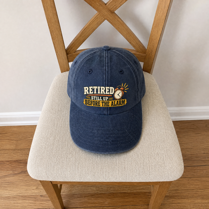 Blue vintage washed cap with printed Retired Still Up Before The Alarm slogan, front view.