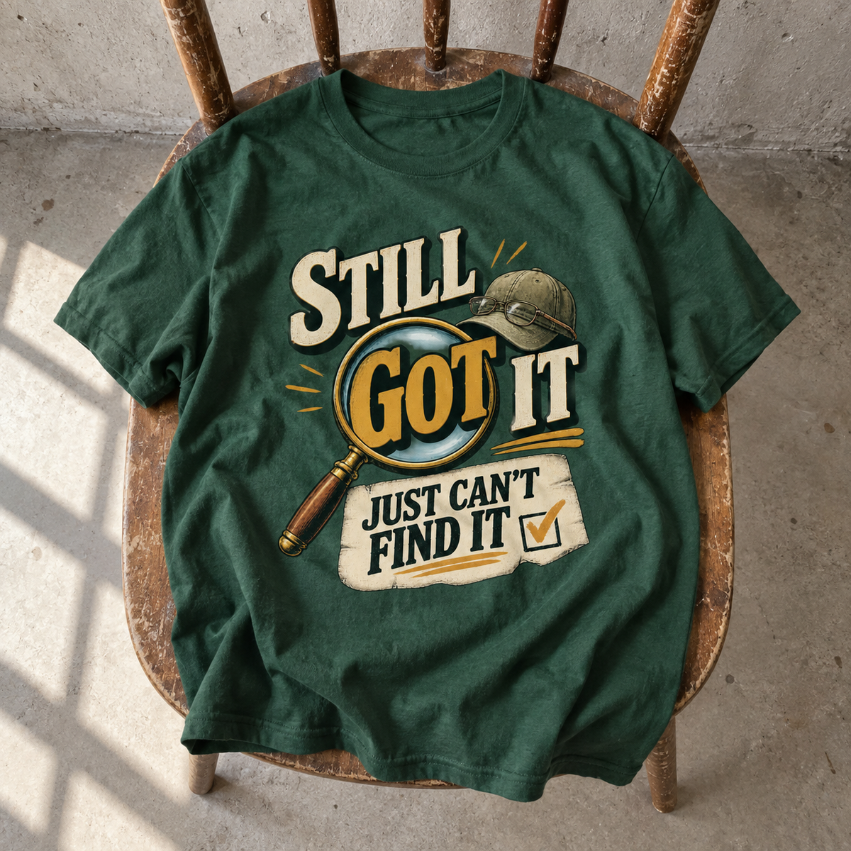 Green vintage t-shirt on chair with printed Still Got It Just Can't Find It slogan