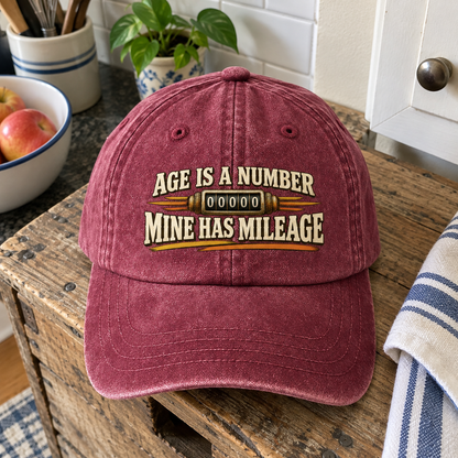 Burgundy vintage washed cap with printed Age Is A Number Mine Has Mileage slogan