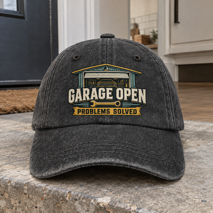 Black vintage washed cap with printed “Garage Open Problems Solved” garage design, front view