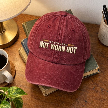 Burgundy vintage washed cap with printed Weathered Not Worn Out slogan on books