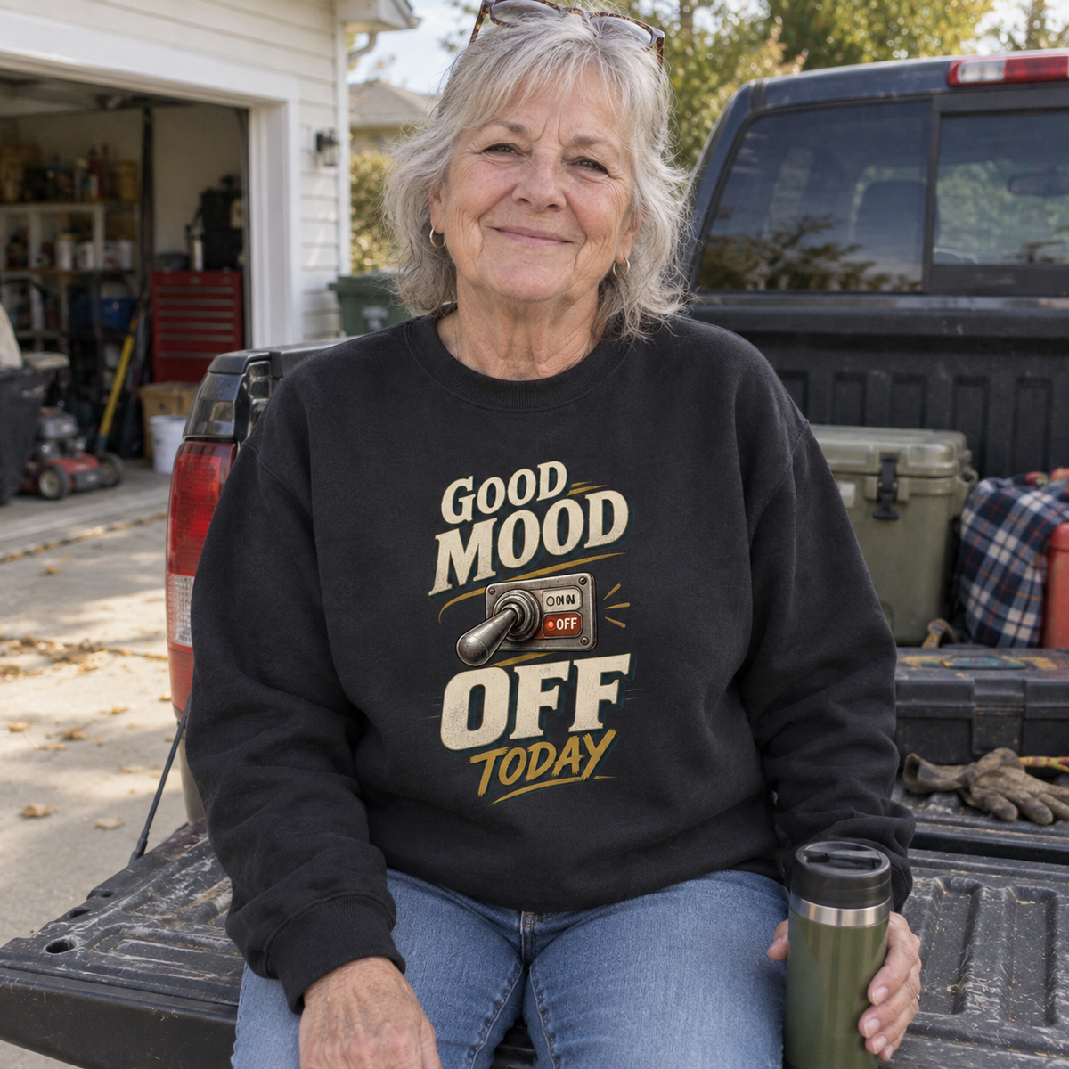 Senior woman seated on truck tailgate wearing black vintage sweatshirt printed Good Mood Off Today.