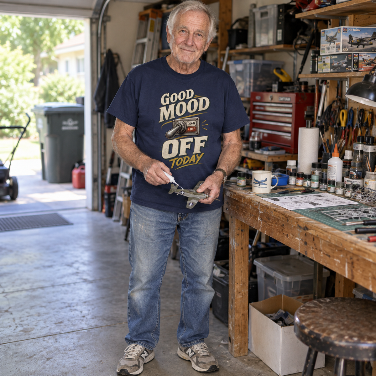 Senior man in garage wearing navy vintage t-shirt printed with Good Mood Off Today