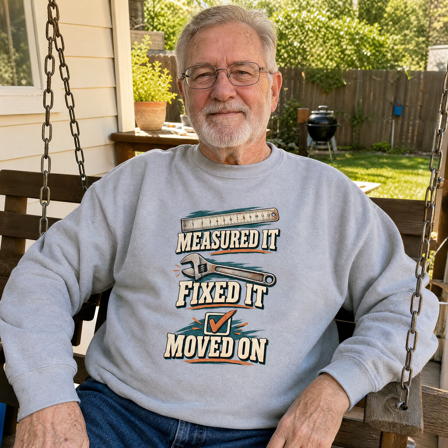 Gray vintage sweatshirt with printed Measured It Fixed It Moved On worn by senior man