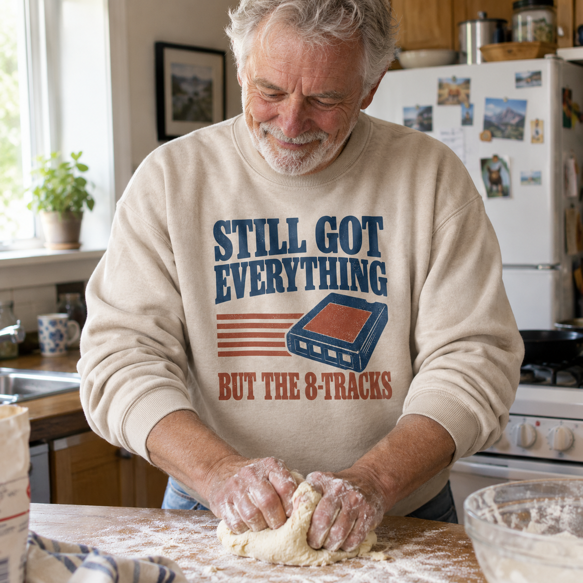 Senior man wearing beige vintage sweatshirt printed Still Got Everything But The 8-Tracks, kneading dough.