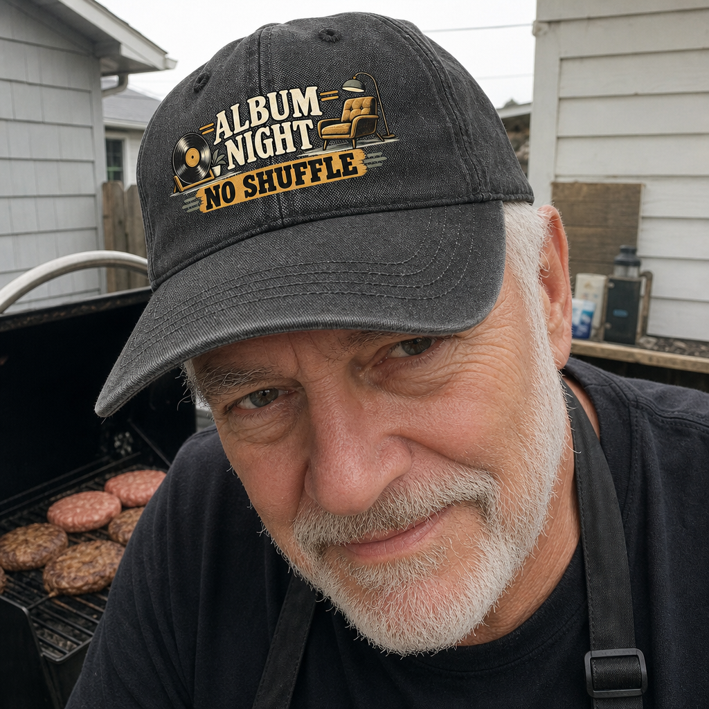 Senior man wearing black vintage washed cap with printed Album Night No Shuffle slogan at grill