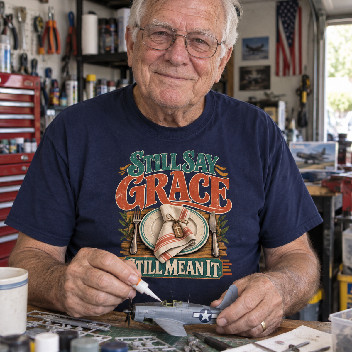 Senior man wears navy vintage t-shirt printed Still Say Grace Still Mean It
