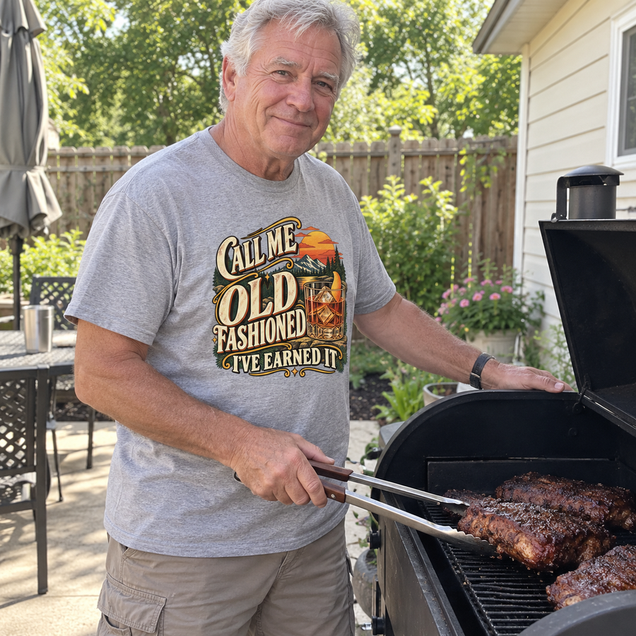 Senior man grilling in gray vintage t-shirt printed Call Me Old Fashioned I've Earned It.