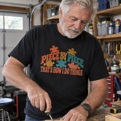 Black vintage t-shirt with printed puzzle pieces and slogan, worn by senior man in garage.