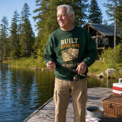 Senior man wearing green vintage sweatshirt printed “Built Before Apps We Figured It Out” fishing
