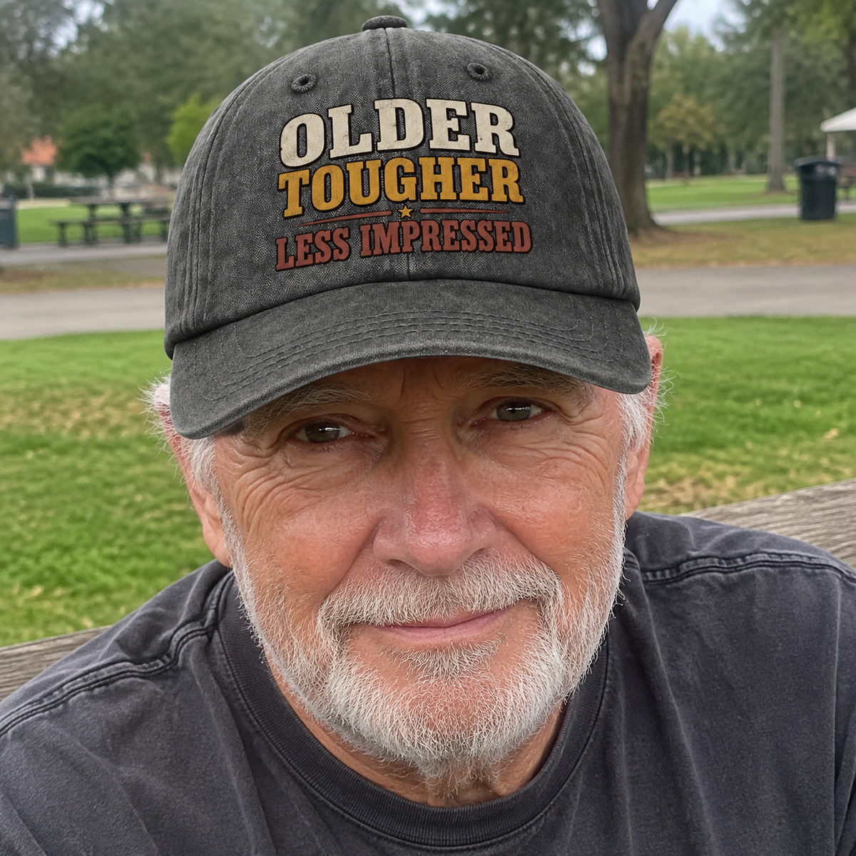 Black vintage washed cap with printed Older Tougher Less Impressed slogan on senior man.