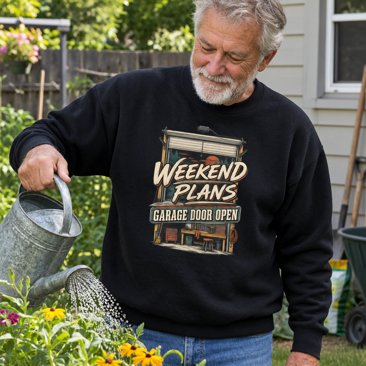 Black vintage sweatshirt with Weekend Plans Garage Door Open print, worn by senior man gardening.