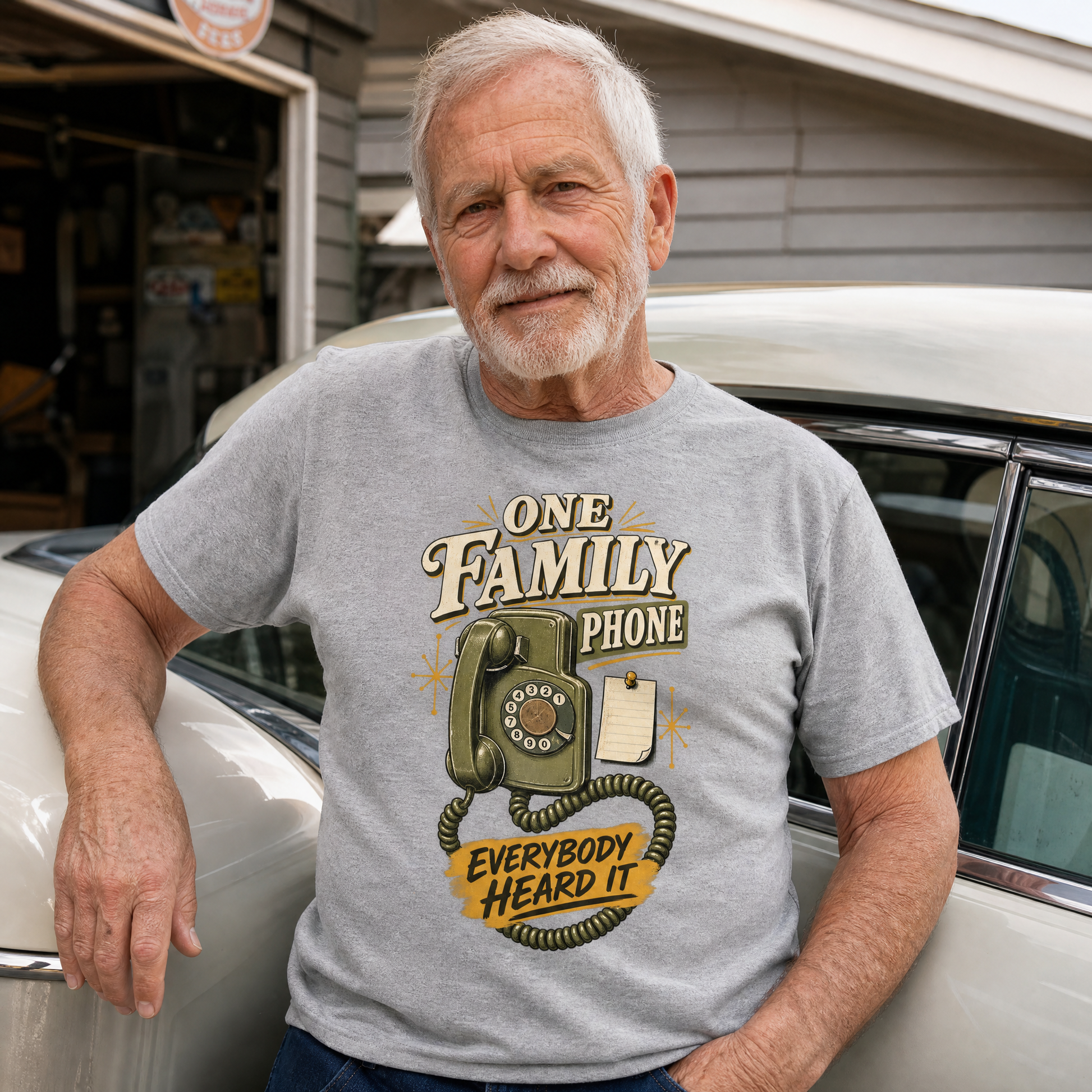Gray vintage t-shirt with printed “One Family Phone” design, worn by senior man beside car