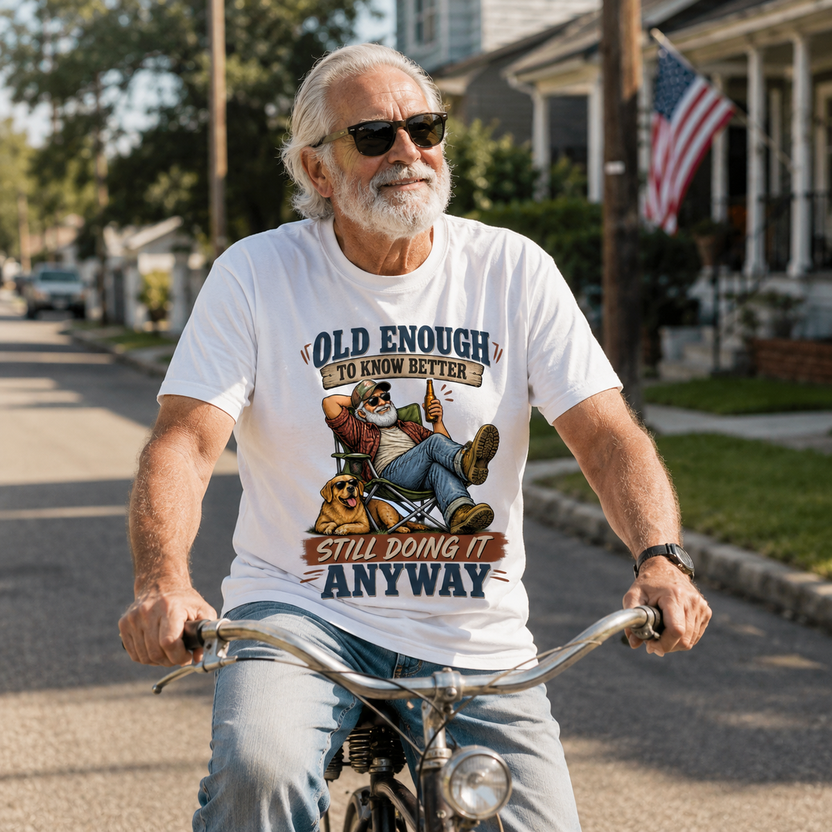 Senior man wearing white vintage t-shirt with printed “Old Enough To Know Better” design, cycling outdoors