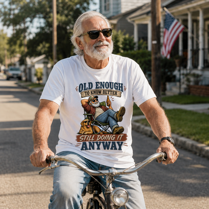 Senior man wearing white vintage t-shirt with printed “Old Enough To Know Better” design, cycling outdoors