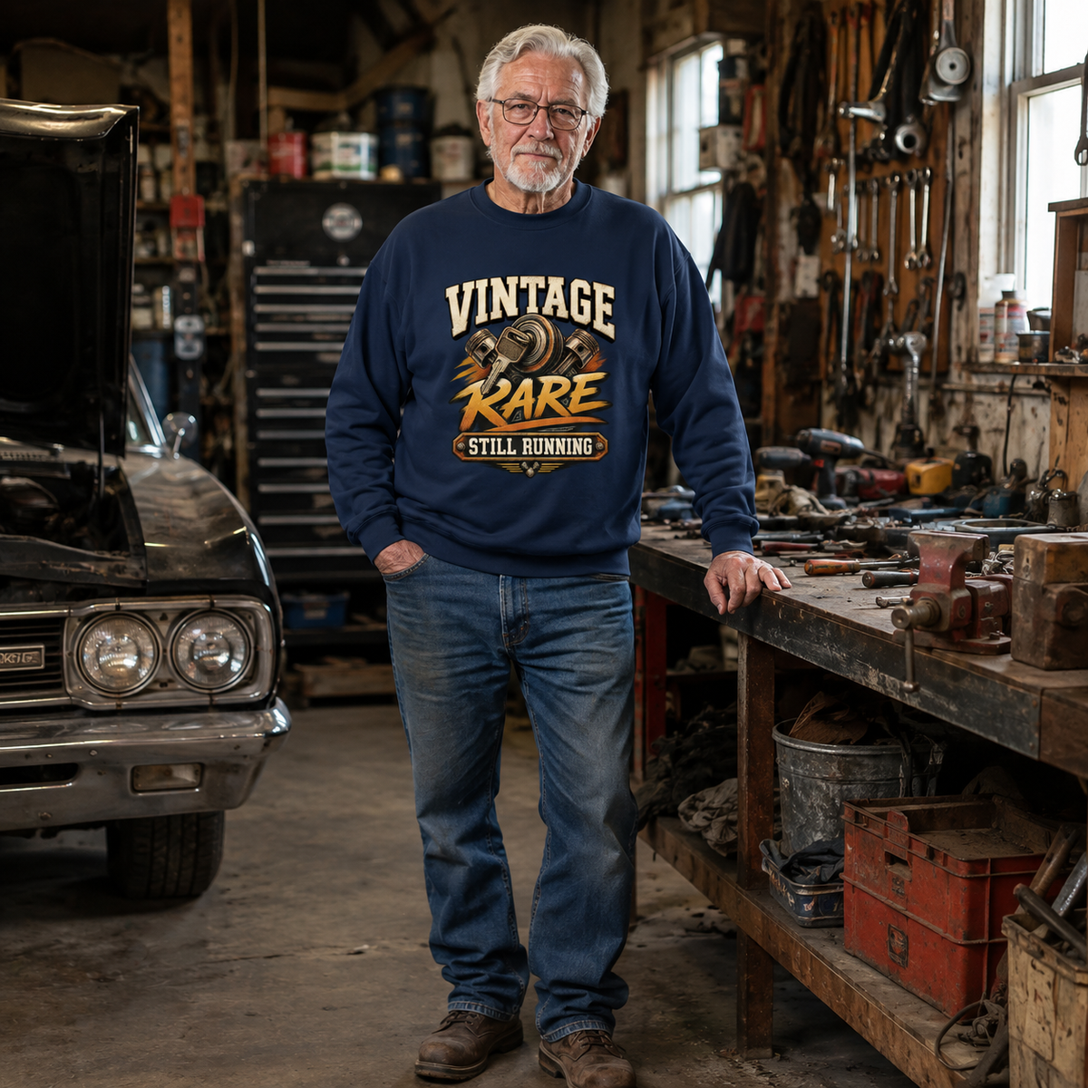 Senior man wearing navy vintage sweatshirt with printed Vintage Rare Still Running design in garage