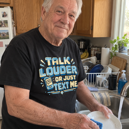 Senior man washing dishes wearing black vintage t-shirt printed Talk Louder Or Just Text Me