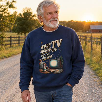 Senior man wearing navy vintage sweatshirt with printed TV slogan, rural sunset lifestyle