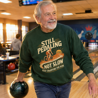 Senior man wearing green vintage sweatshirt with printed cycling slogan at bowling alley.