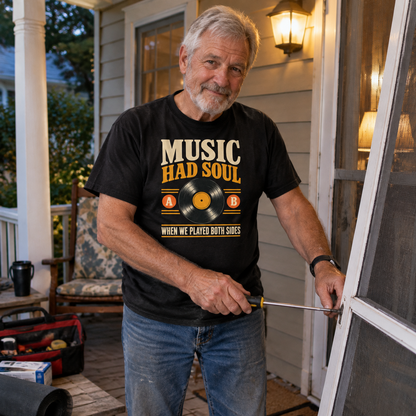 Black vintage t-shirt with printed Music Had Soul slogan worn by senior man on porch.