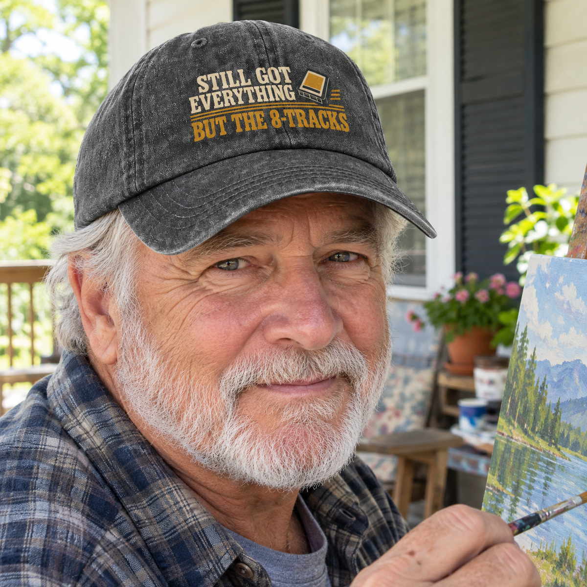 Senior man wears black vintage washed cap with printed 8-Tracks slogan while painting outdoors.